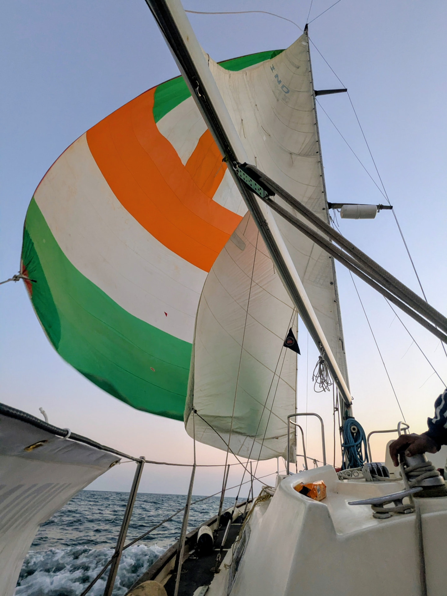 Tricolour spinnaker filling at dusk on the Arabian Sea